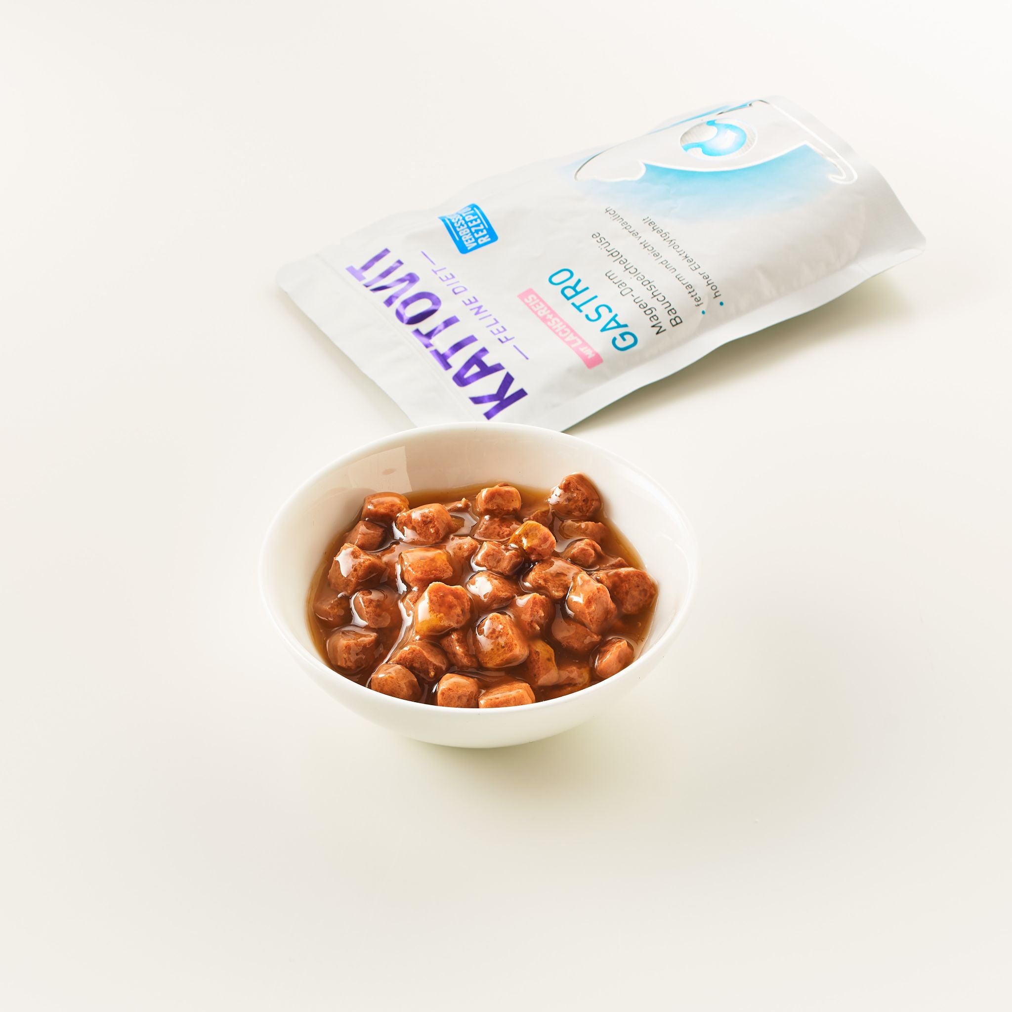 KATTOVIT Gastro Katzenfutter mit braunen Brocken in Soße, halbgeöffnete Verpackung sichtbar.