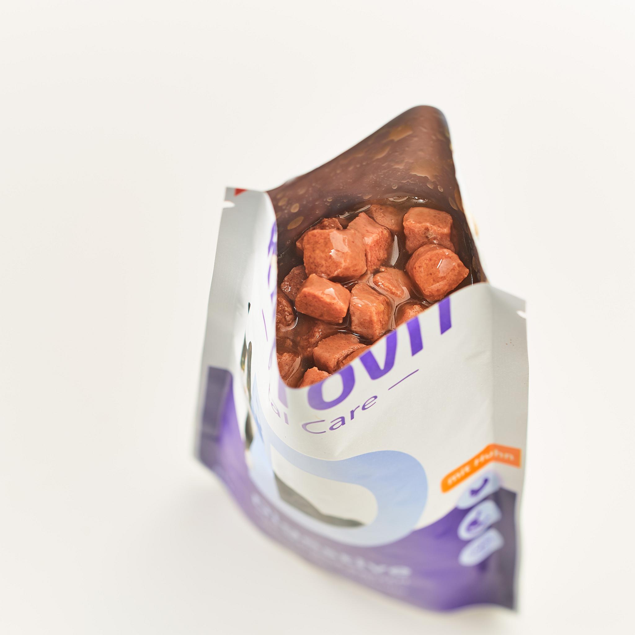 Eine geöffnete Packung mit Katzenfutter Digestive, in der kleine, braune Fleischstücke in einer dunklen Sauce sichtbar sind.